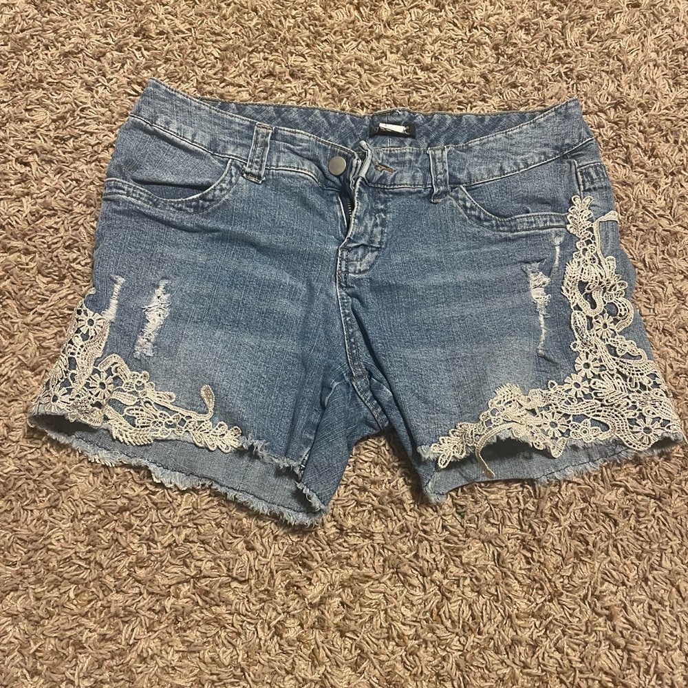 Distressed denim shorts with lace detailing